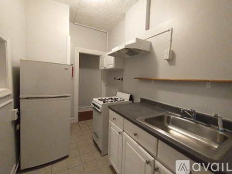 A kitchen with white appliances and a stove top oven.