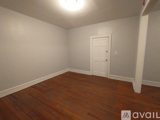 A room with a wooden floor and a white door.