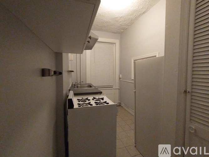 A kitchen with a stove top oven and a sink.
