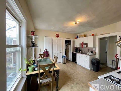 A kitchen with a table and chairs in front of a window.