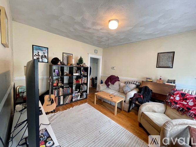 A living room with a television, a couch, and a bookshelf.