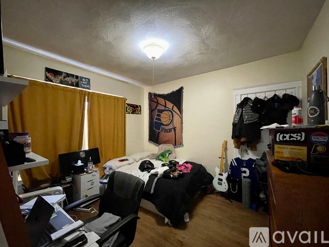 A bedroom with a bed, desk, and chair.