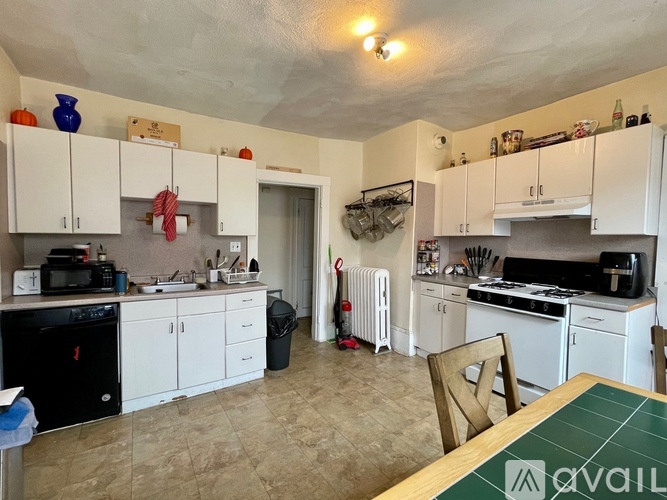 A kitchen with white cabinets and a green table.