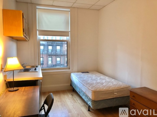 A bedroom with a bed, desk, and chair.