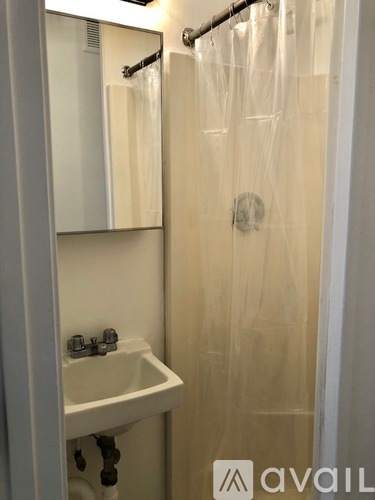 A white sink with a mirror above it and a shower curtain.