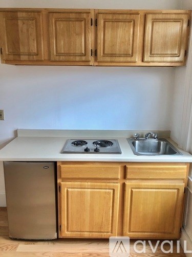 A kitchen with wooden cabinets and a stove top oven.