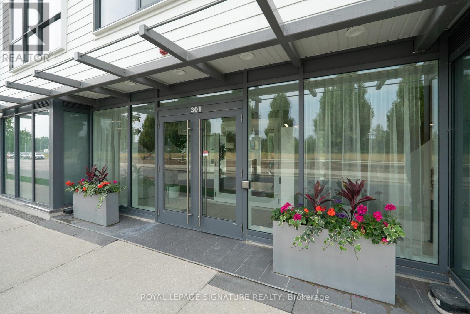 The entrance to a building with glass doors and windows, with a number 301 on the door.