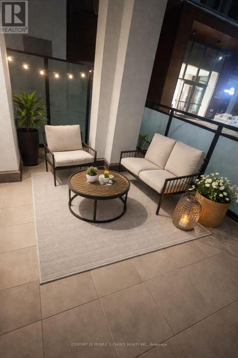 A patio with a table, chairs, and plants.