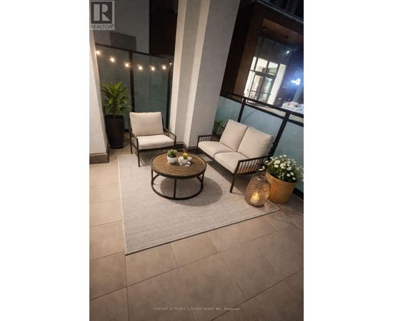 A patio with a table, chairs, and plants.