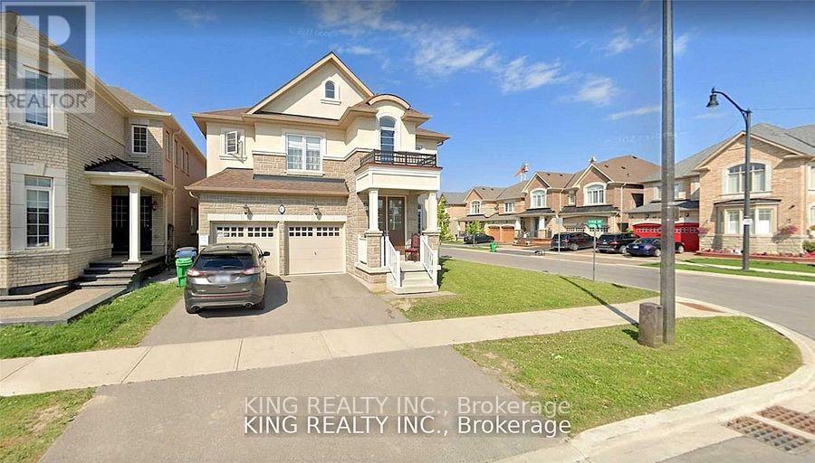 A residential street with houses and a car parked on the side.