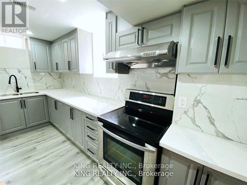 A kitchen with white cabinets and marble countertops.