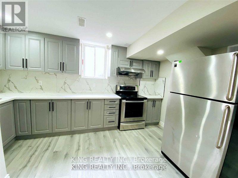 A kitchen with a refrigerator, cabinets, and a countertop.