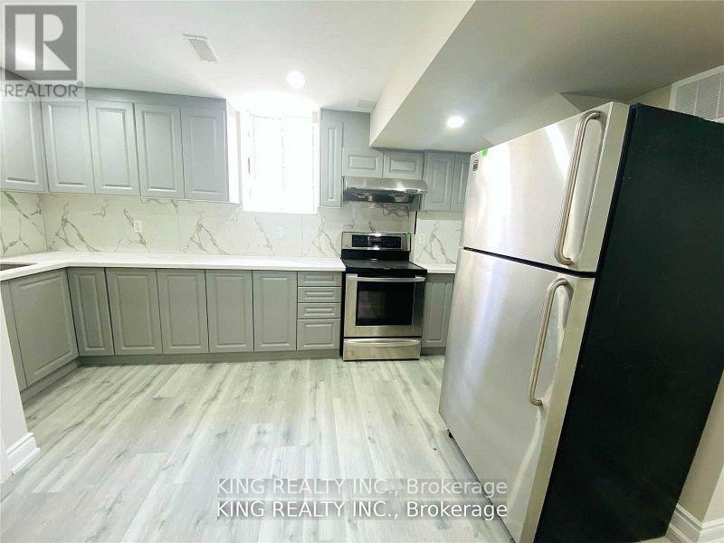 A kitchen with a black refrigerator and white cabinets.