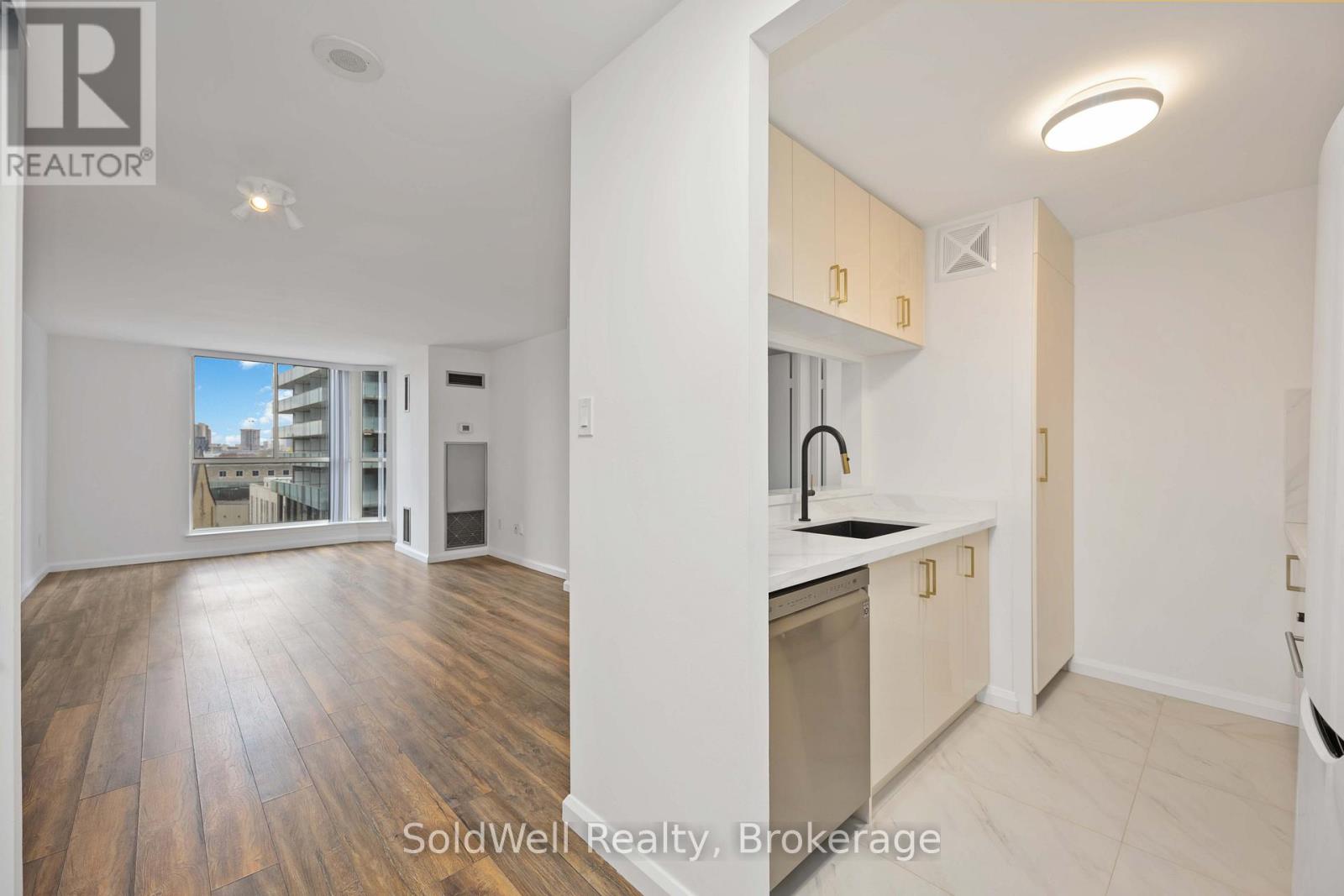 A kitchen with wooden floors and white walls.