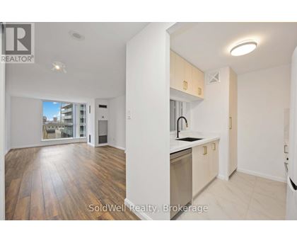 A kitchen with wooden floors and white walls.
