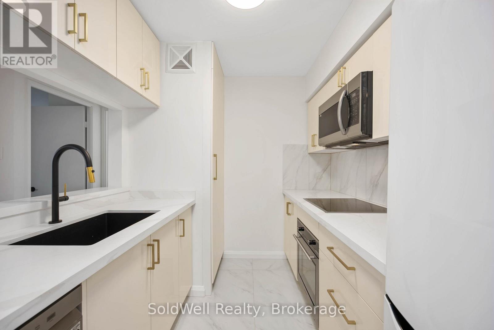A kitchen with white cabinets and a black counter top.