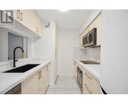 A kitchen with white cabinets and a black counter top.