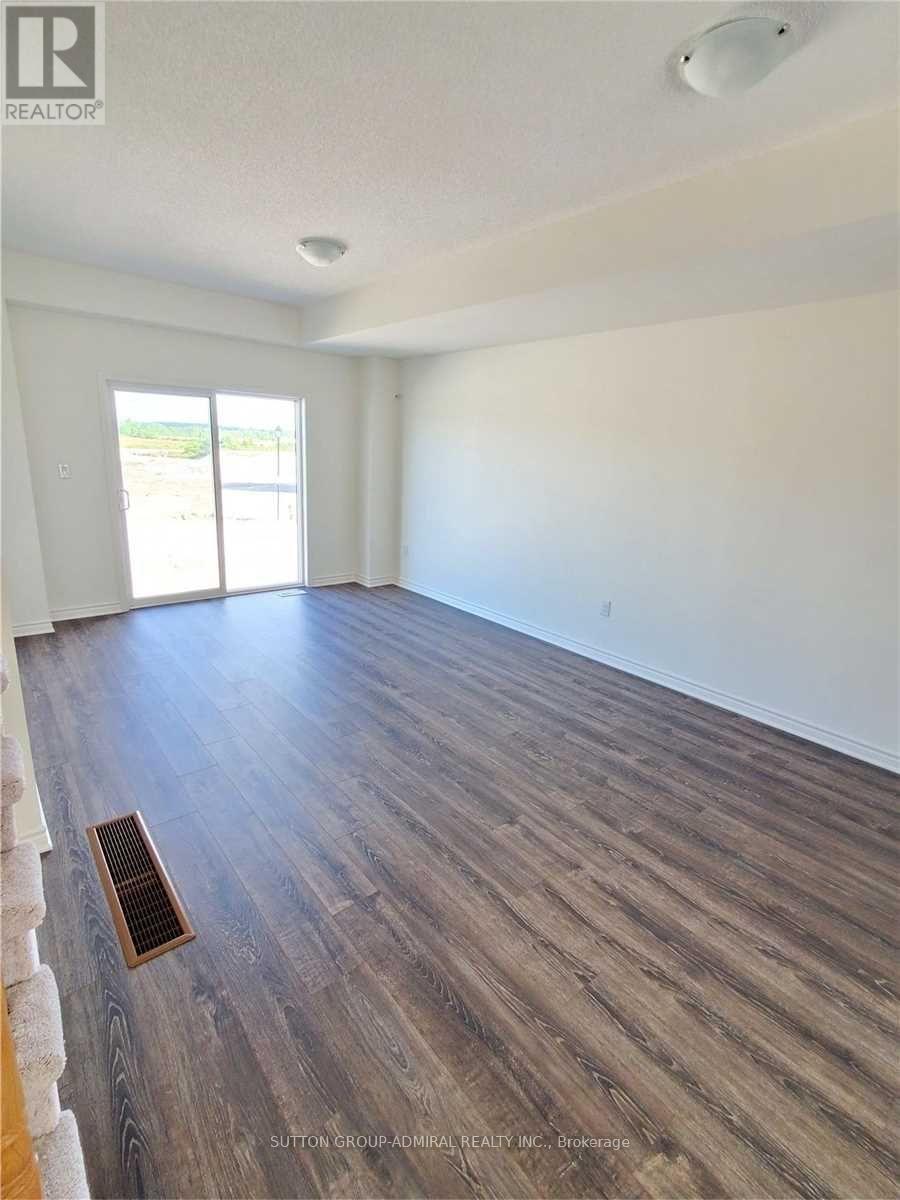 A room with wooden flooring and a window overlooking a parking lot.