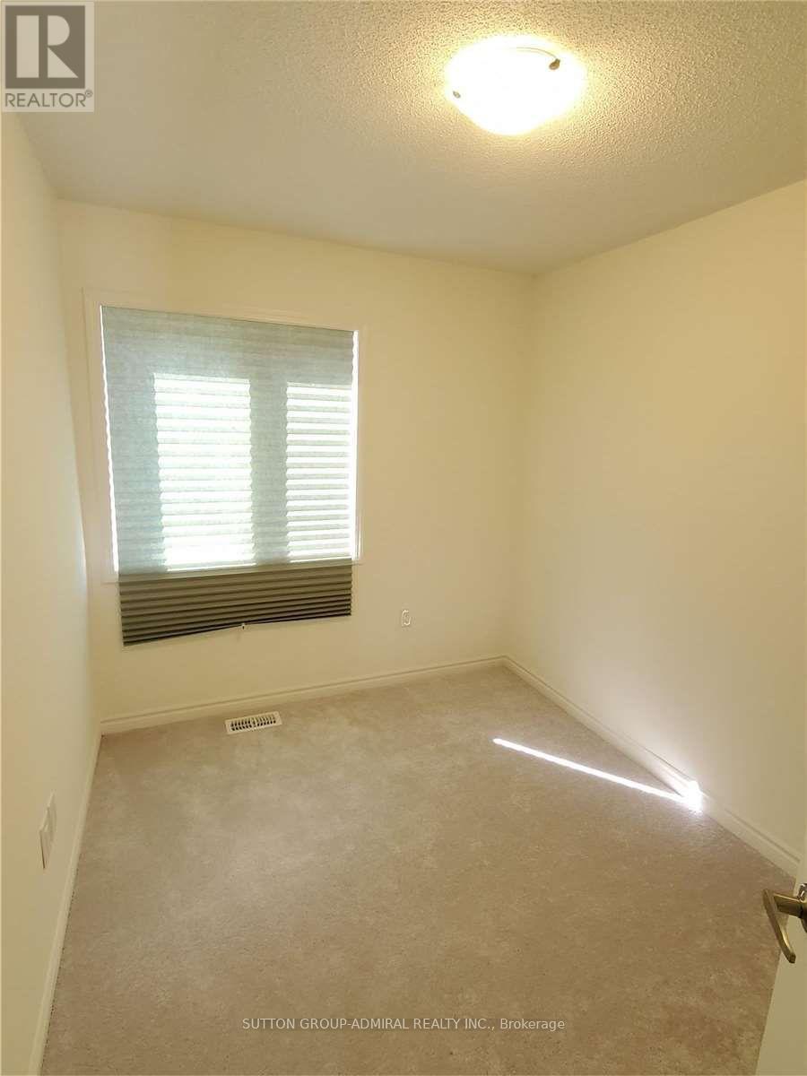 A room with a window and a carpeted floor.