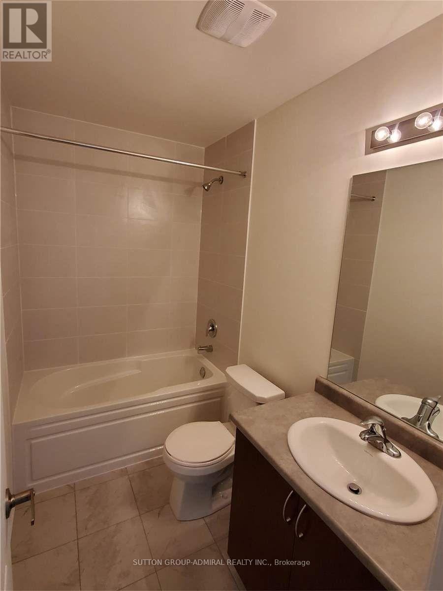 A white bathroom with a toilet, sink, and bathtub.