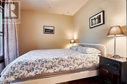A bedroom with a bed, nightstand, and lamp.