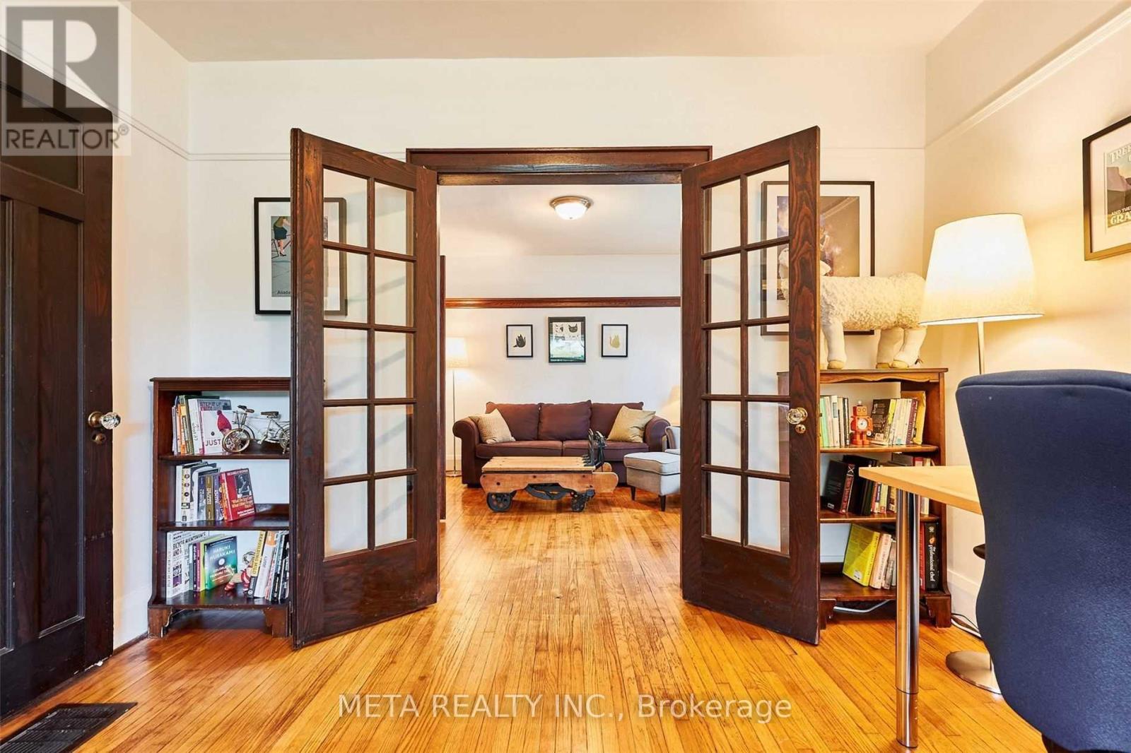 A living room with a couch, a chair, and a bookshelf.