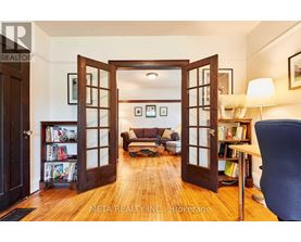 A living room with a couch, a chair, and a bookshelf.
