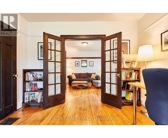 A living room with a couch, a chair, and a bookshelf.