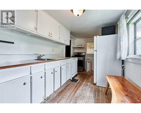 A kitchen with white cabinets and a wooden floor.