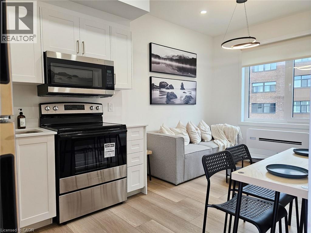 A modern kitchen with a black oven and microwave above a white cabinet.