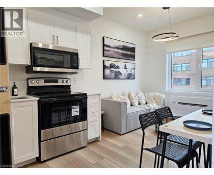 A modern kitchen with a black oven and microwave above a white cabinet.
