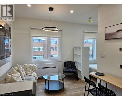 A living room with a couch, chairs, and a coffee table.