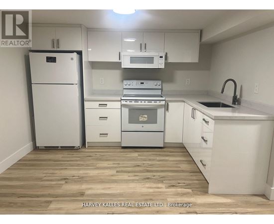 A kitchen with white appliances and cabinets.