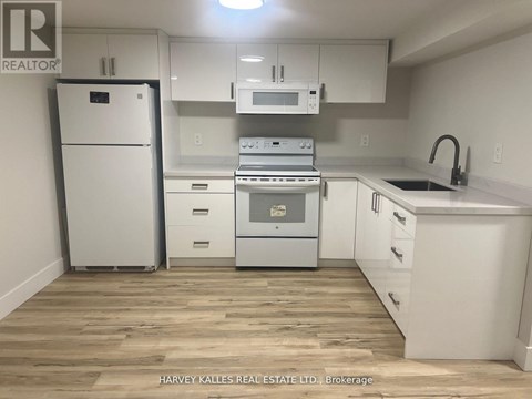 A kitchen with white appliances and cabinets.