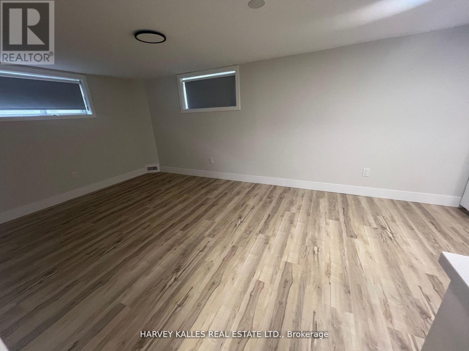 A room with wooden flooring and a window.