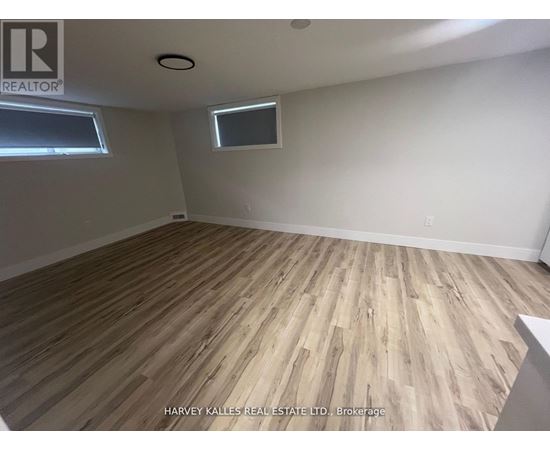 A room with wooden flooring and a window.