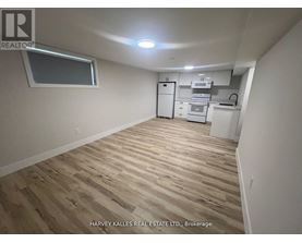 A kitchen area with wooden flooring and white appliances.