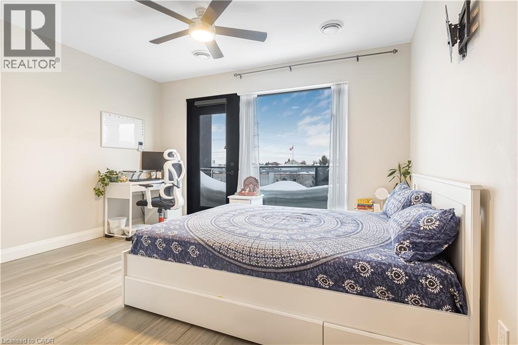 A bedroom with a bed, a ceiling fan, and a window with a view of a snowy landscape.