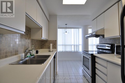 A kitchen with white cabinets and a tiled backsplash.