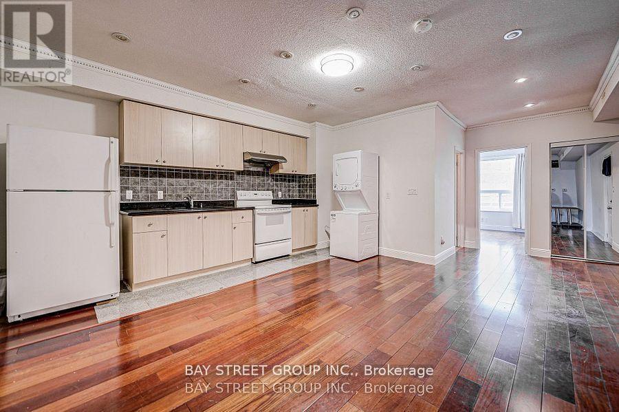 A kitchen with white appliances and wooden cabinets.