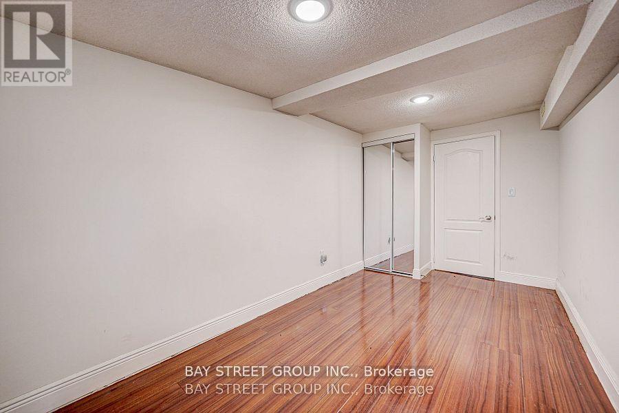 A room with a wooden floor and white walls, with a door on the right side.