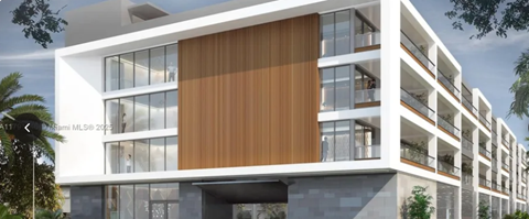 A modern building with a white facade and a large wooden panel on the side.