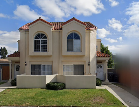 A house with a red tile roof and white walls.