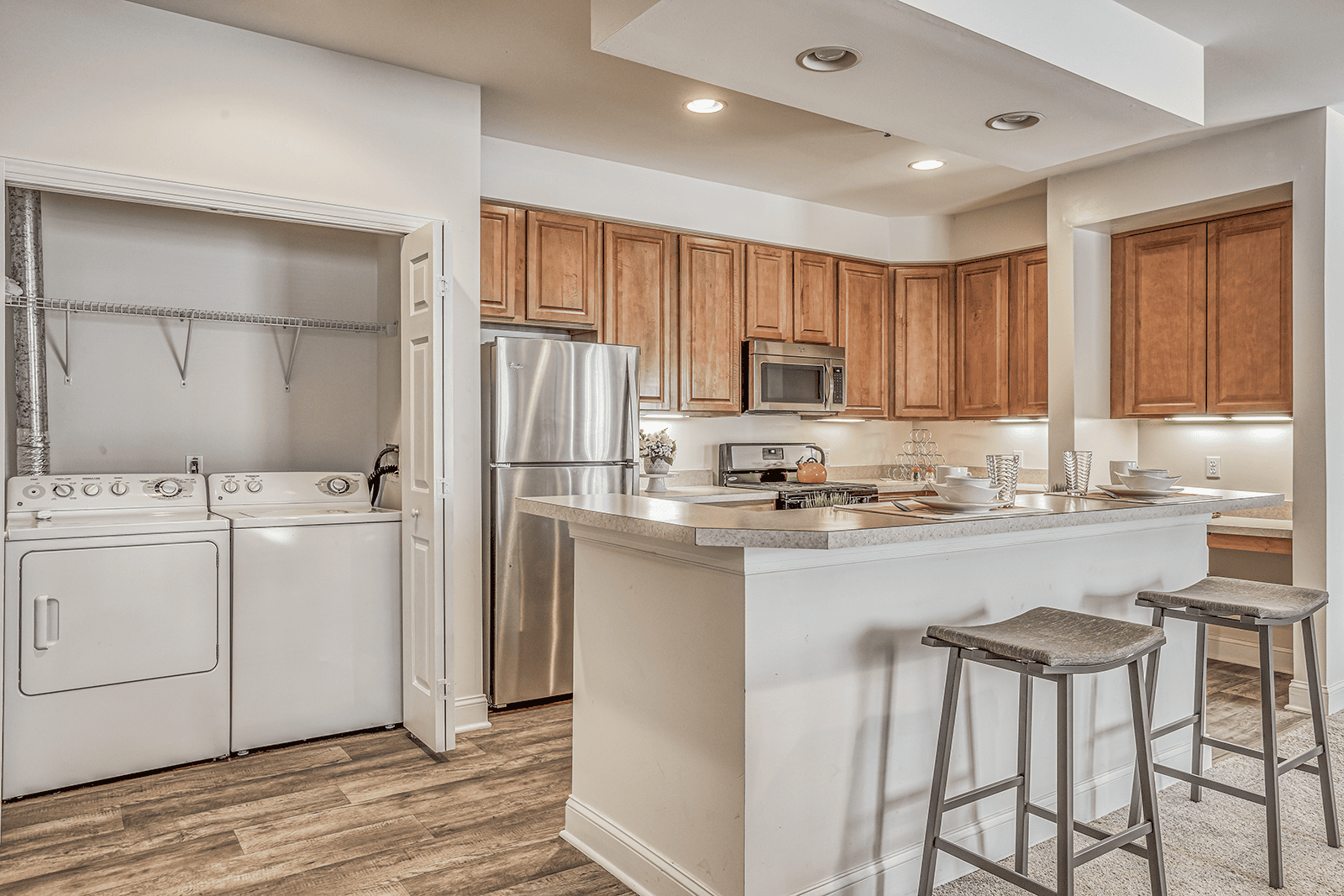 A kitchen with wooden cabinets and a white island.