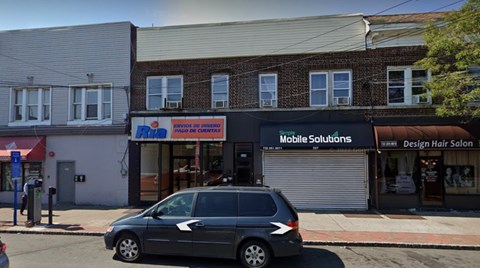 A car is parked in front of a building with a sign that says "Mobile Solutions".