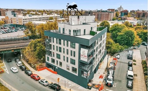 A building with a bull statue on top and cars parked in front.
