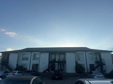 A white building with a black staircase in front.