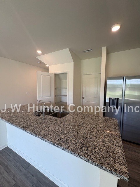 A kitchen counter with a granite top and white cabinets.