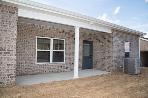 A house with a brick wall and a door.