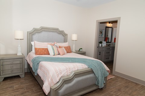 A bedroom with a bed, nightstands, and a dresser.